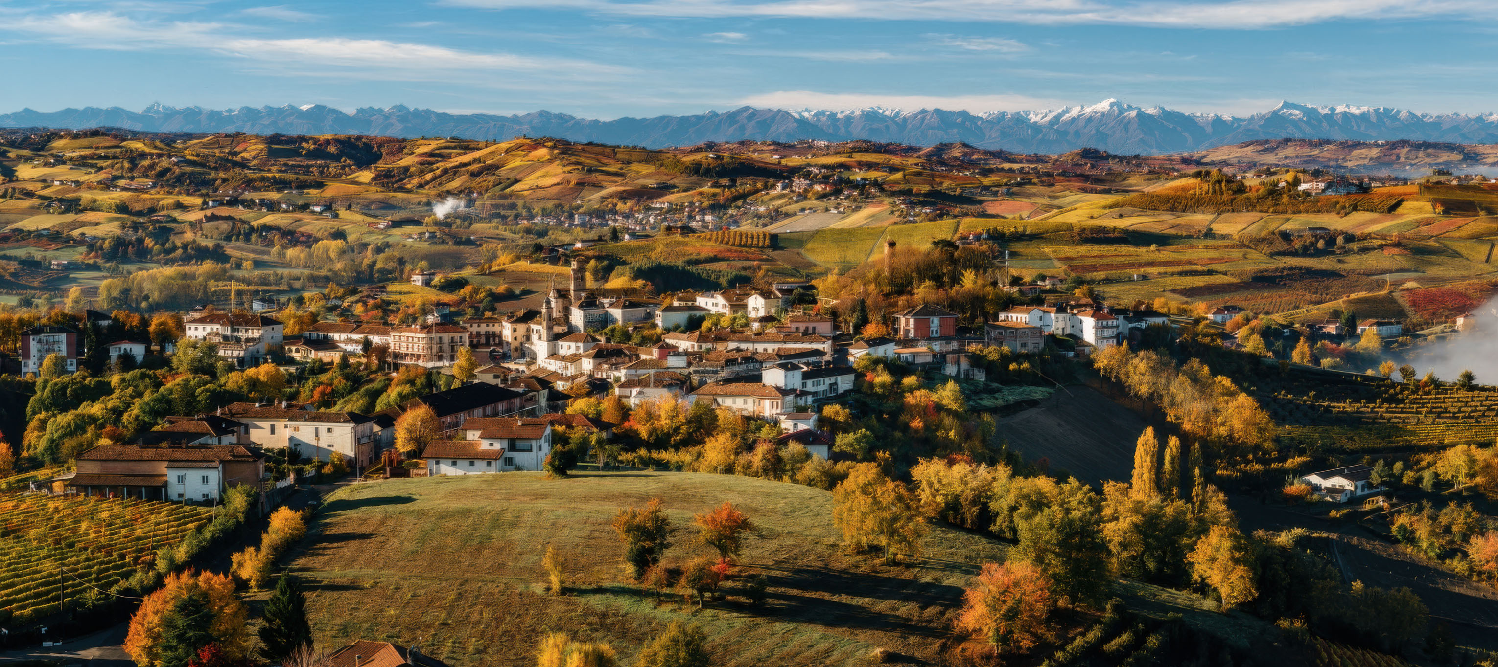 Castagnole delle Lanze among autumn hills, with the Alps beyond