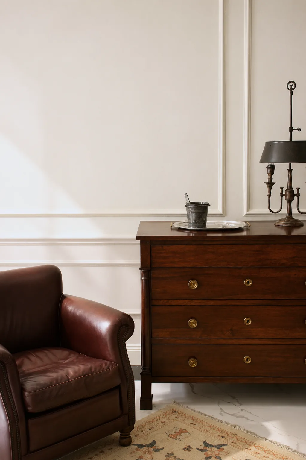 Leather armchair beside a mahogany chest of drawers