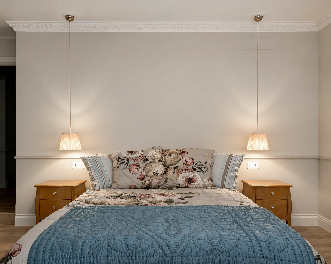 Bedroom with floral headboard and blue coverlet