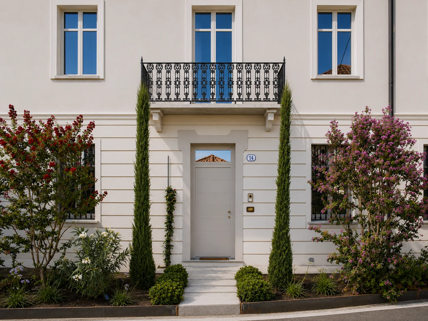 Restored façade of the house framed by flowering trees